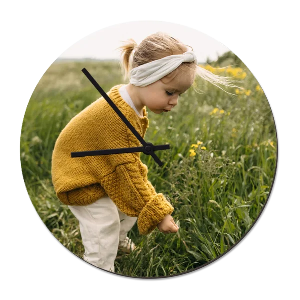 Runde Wanduhr mit Foto eines kleinen Mädchens auf einer Blumenwiese – personalisiertes Design für individuelle Raumdeko.